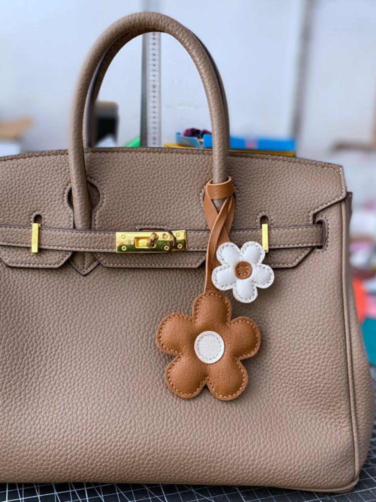 Handmade brown and white flower leather bag charm—crafted from supple leather with engraved details. A luxury yet elegant accessory for your bag. 