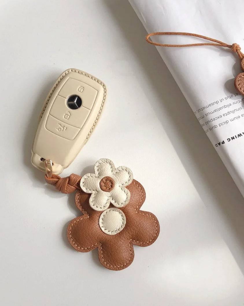 Handmade brown and white flower leather bag charm—crafted from supple leather with engraved details. A luxury yet elegant accessory for your bag. 